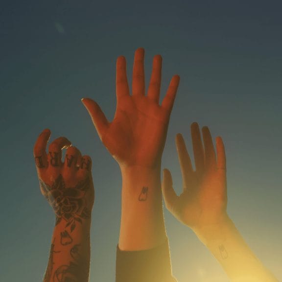 The cover art for 'The Record'. Each member of the band's hands are in front of a blue background, reaching towards the sky. 