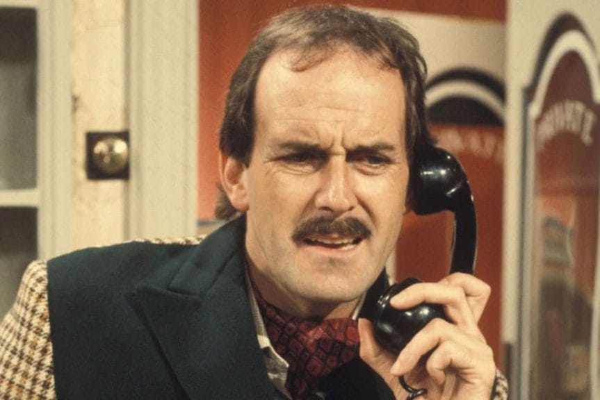 John Cleese as his character Basil Fawlty talking on the phone in an episode of Fawlty Towers 