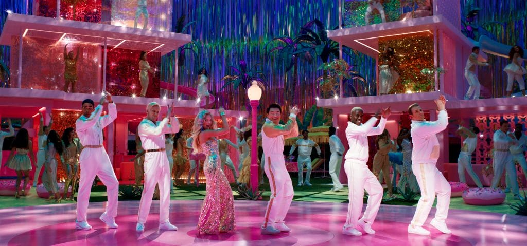 Barbie played by Margot Robbie, surrounded by Ken dolls as everyone dances. Image represents soundtrack for the film