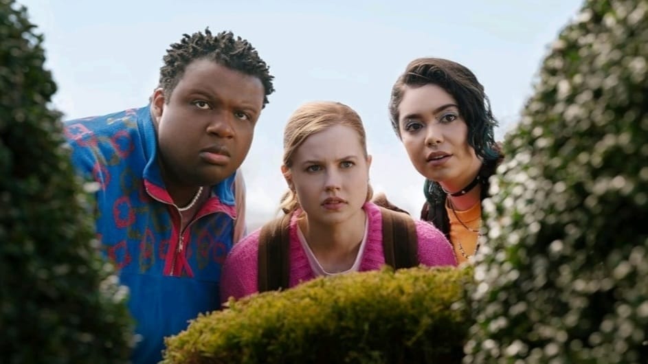 Damien, Cady, and Janice hiding behind bushes in a still from 'Mean Girls.'