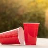 Picture of two plastic red solo Cups; one in a laying down postion and one in a straight-up postion.