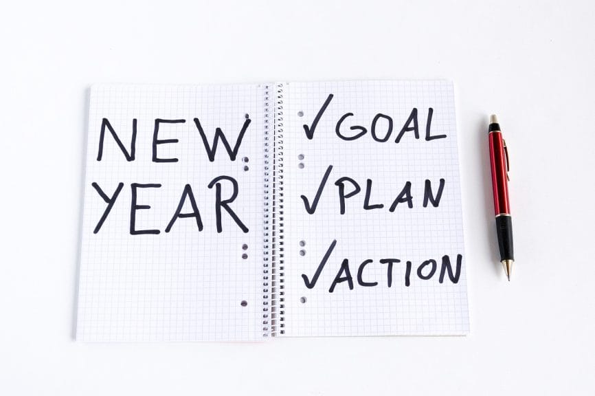 Notebook message that reads "New Year - Goal, Plan, Action" with each checked off. 