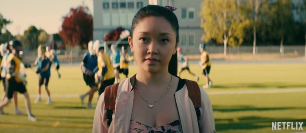 Lara-Jean, a dark haired Asian girl stands in a football pitch