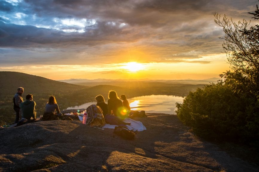 Group of people having a scenic picnic atop a mountain.