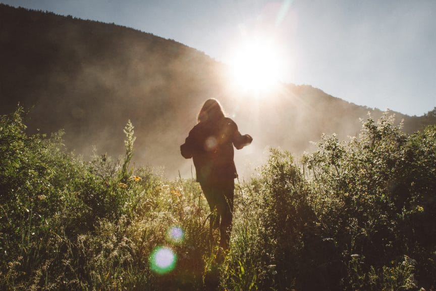 Girl hiking towards the sun