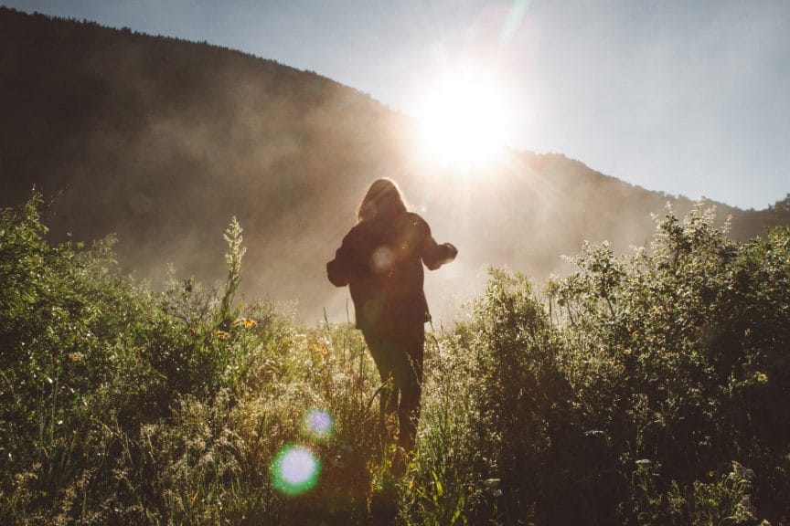 Girl hiking towards the sun 