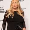 Image of Jennifer Coolidge standing on a red carpet with her lips perked.