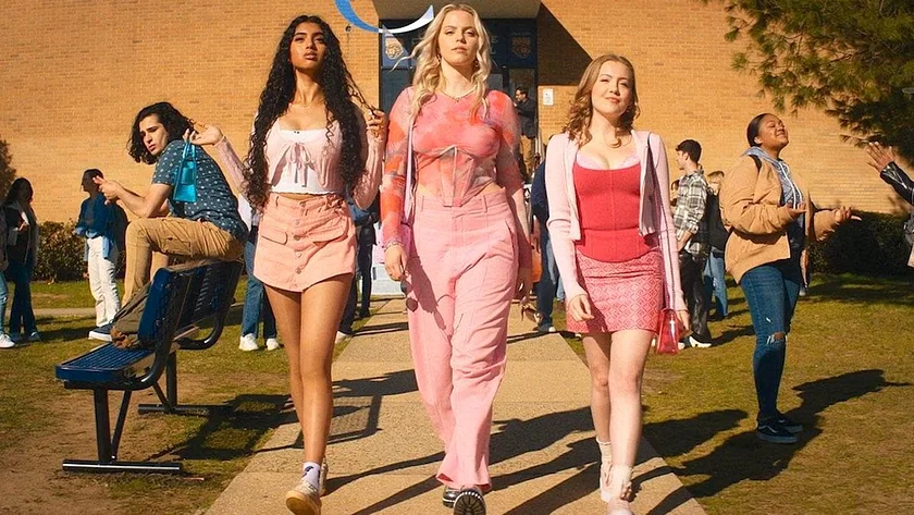 Promotional still from Mean Girls. It features three girls walking together dressed in pink outfits.
