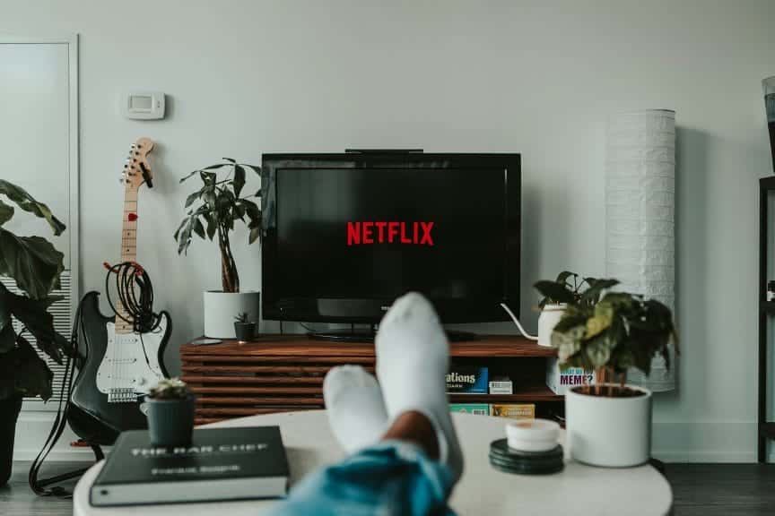 Socked feet kicked up on table having fun watching Netflix.