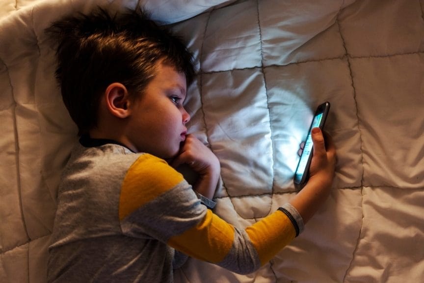 Young boy on phone parents suing social media companies for harming children