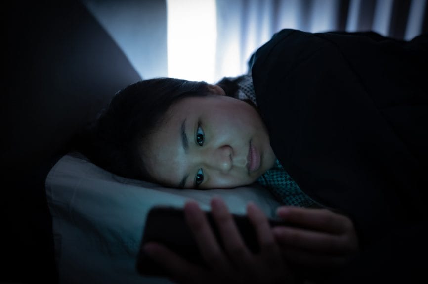 Girl on phone in bed