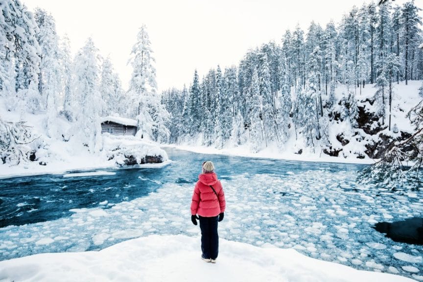 Rear view of a pre-teen girl enjoying breathtaking views of the winter landscape in Oulanka National Park in Lapland, Finland.