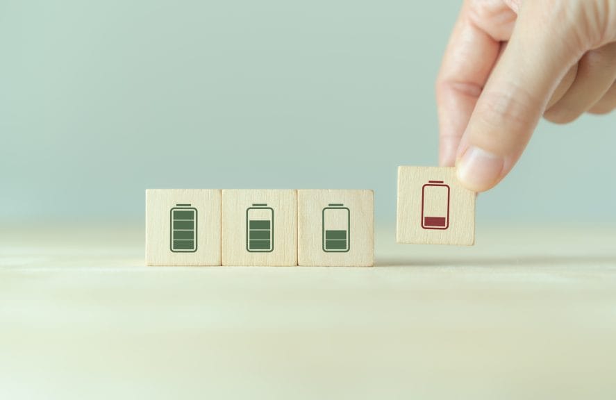 Four squares with a battery image in them and the battery gets lower through the squares. The last square is being picked up by a person's hand.