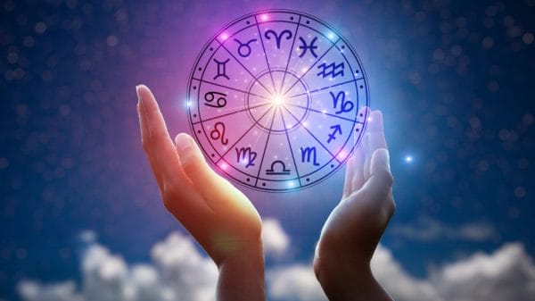 Person holding horoscope circle of zodiac signs.