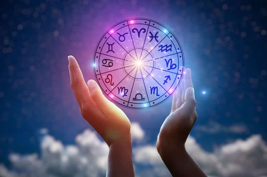 Person holding horoscope circle of zodiac signs.