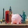 A piggybank placed among a display of miniatures of various landmarks and items from around the world.