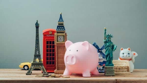 A piggybank placed among a display of miniatures of various landmarks and items from around the world.