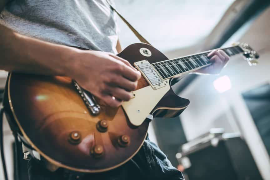 Man strumming an electric guitar.