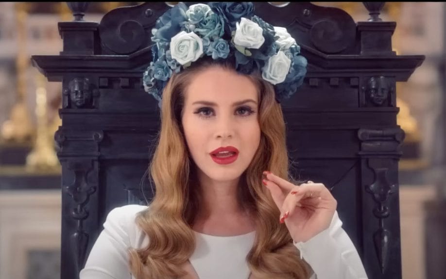 Lana Del Rey in her 2012 Music Video for "Born to Die" close up with large blue and white flower crown