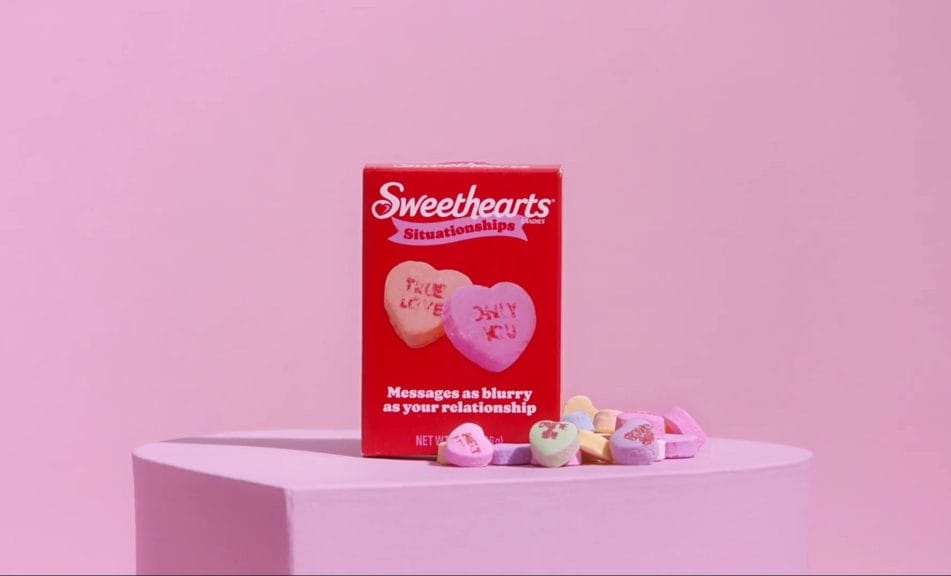 Box of heart-shaped candies with blurred messages printed on.