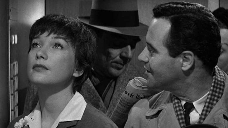 Fran Kubelik (Shirley McLaine, left) and C.C. Baxter (Jack Lemmon, right) are talking to each other on the elevator.