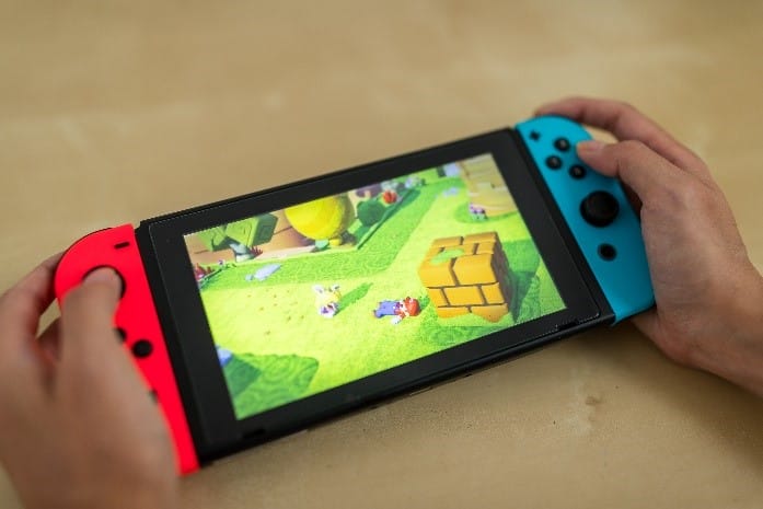 A person playing a Mario game on the switch gamepad.