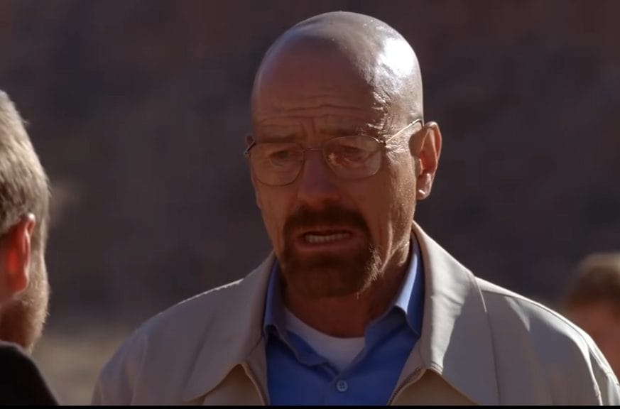Walter White wears an upset expression as he looks at a friend in danger in the desert.