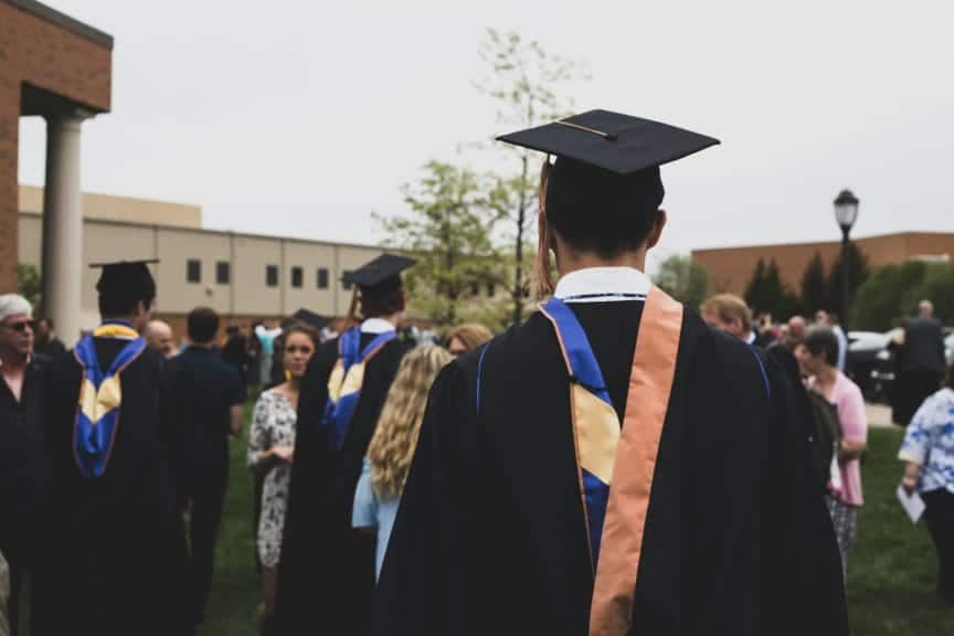 Graduation day at college. Everyone is in cap and gowns and with their families outside.