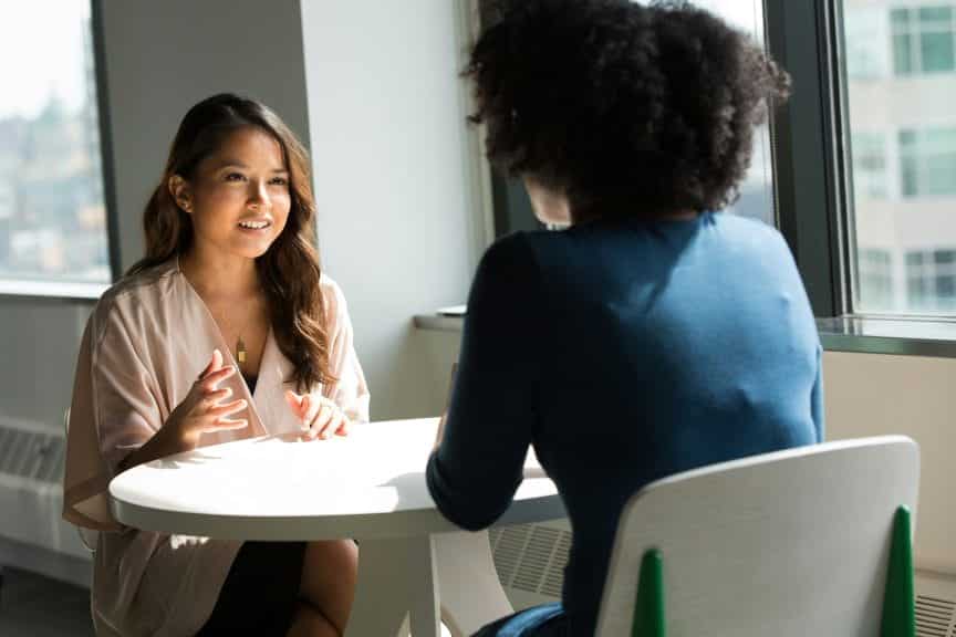 Two women talking to each other across a table