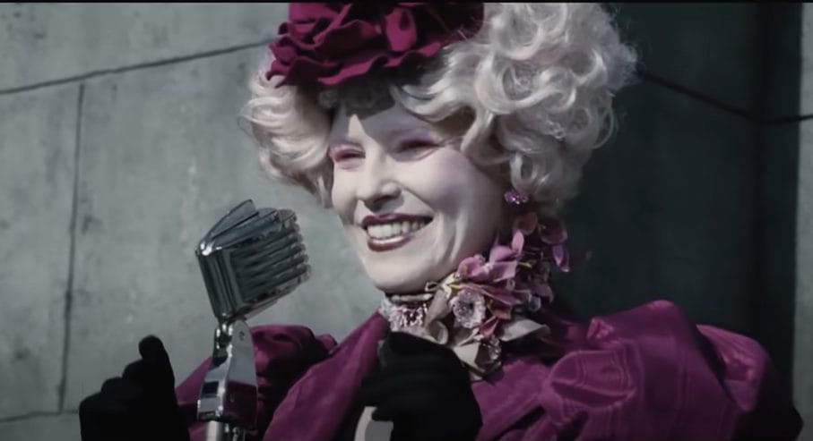 Effie Trinket (The Hunger Games) in purple floral outfit.
