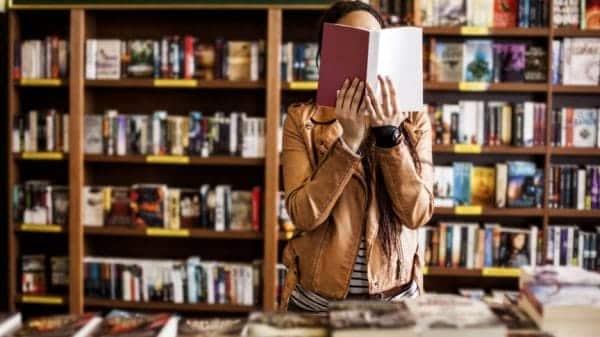 woman reading a book in a library or book shop