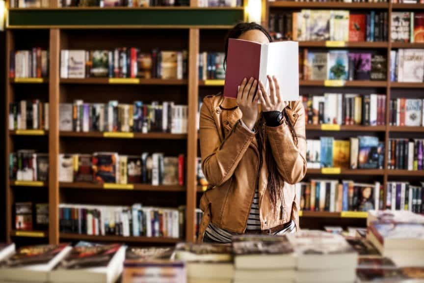 woman reading a book in a library or book shop