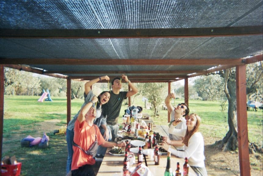 A group of friends eating calçots at a picnic table in Catalonia.