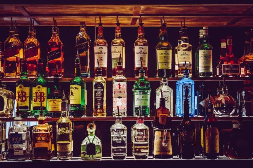 A photo displaying numerous bottles of liquor at a bar.
