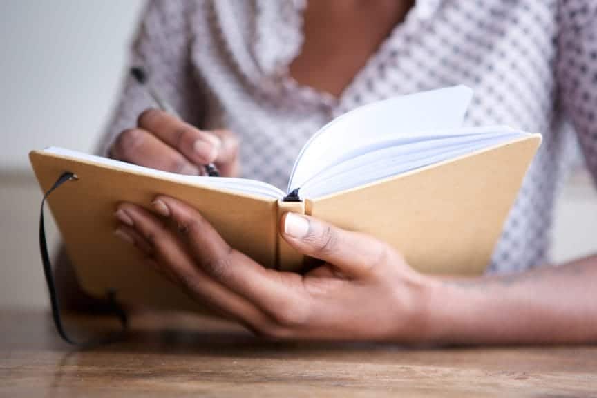 Person writing in an open notebook. whether you're an academic weapon or academic victim, studying is key for getting through school.