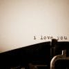 Dimly lit paper with a romantic typewriter message reading "i love you".