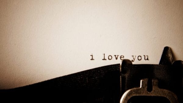 Dimly lit paper with a romantic typewriter message reading "i love you".