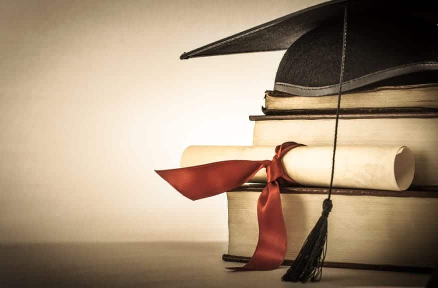 Graduation cap on top of a stack of books. 