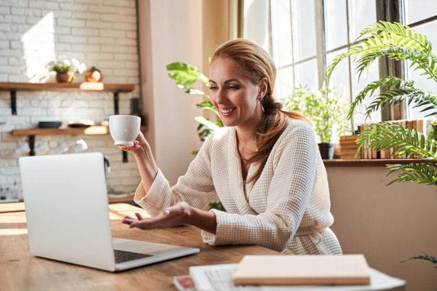 Woman in bathrobe working on computer.