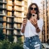 Portrait of a Successful Business woman Using iPhone pro with coffee cup.