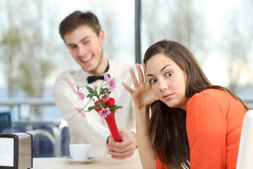 A women is unimpressed by a man offering her flowers