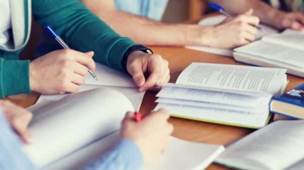 Students studying at a table with open books.