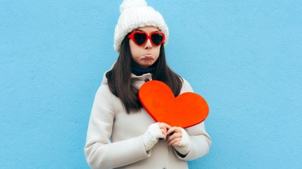 sad woman holding paper craft heart