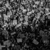 A crowd of protesters holding placards during a march.