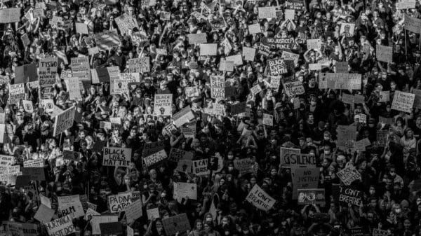 A crowd of protesters holding placards during a march.