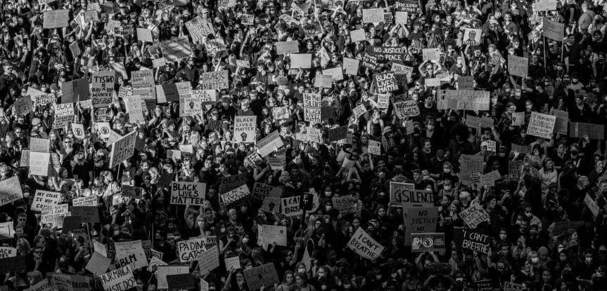 A crowd of protesters holding placards during a march.