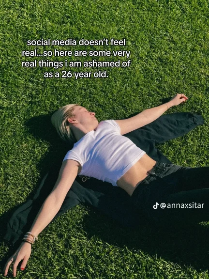 Anna Sitar lying in the grass with the statement, “social media doesn’t feel real, so here are some very real things I am ashamed of as a 26 year old.”