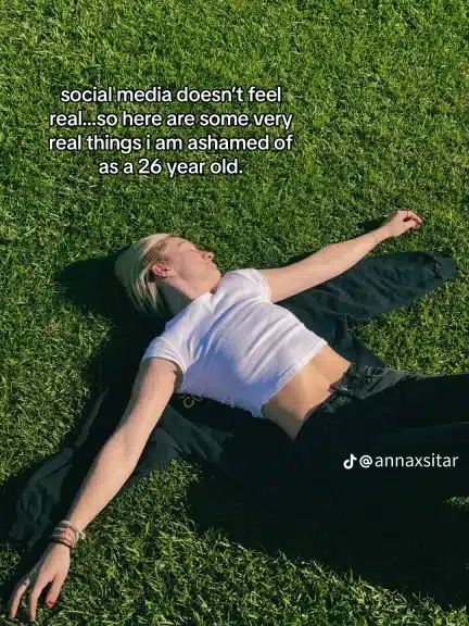 Anna Sitar lying in the grass with the statement, “social media doesn’t feel real, so here are some very real things I am ashamed of as a 26 year old.”