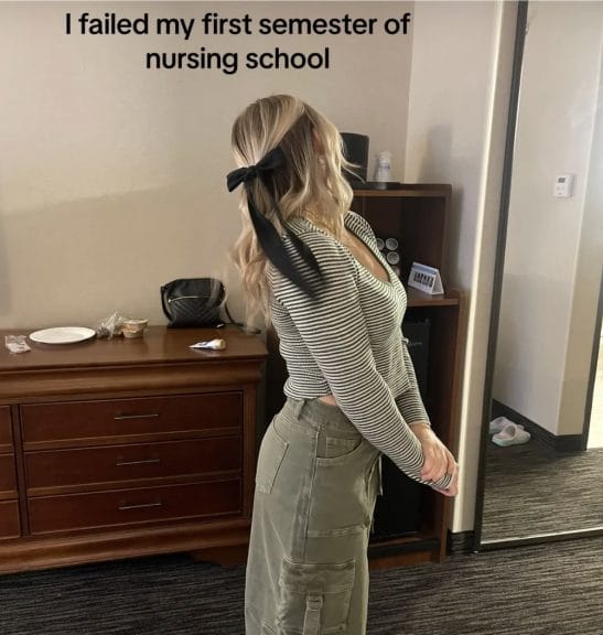 Maddi Cobbley poses in a hotel room with the statement, “I failed my first semester of nursing school.’