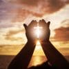 Prayer hands in front of Ocean.